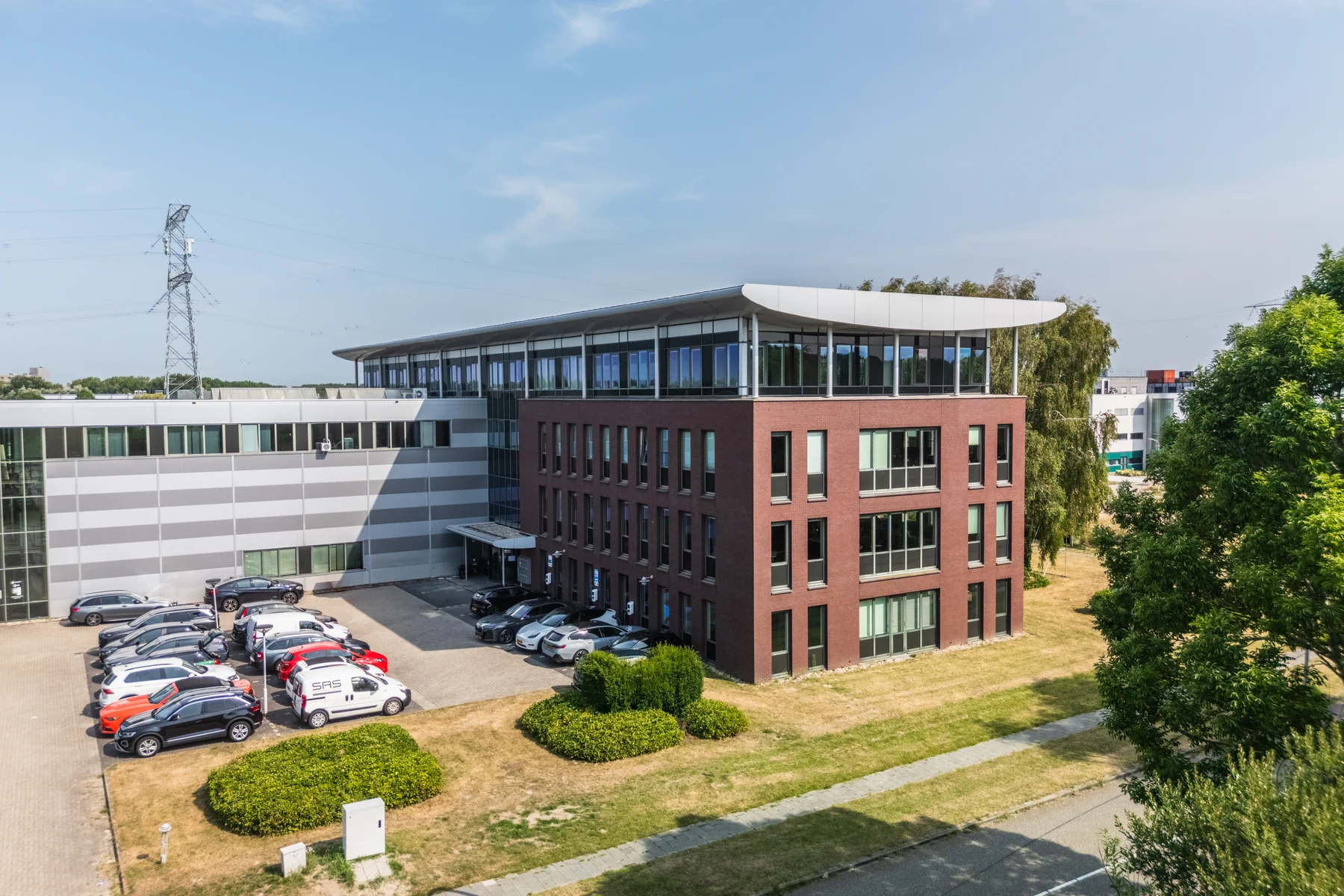 Het pand aan Transistorstraat 40–46 in Almere, met een rode bakstenen gevel en glazen bovenverdieping.