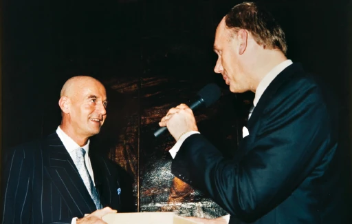 Pim Fortuyn naast een gast met een microfoon.
